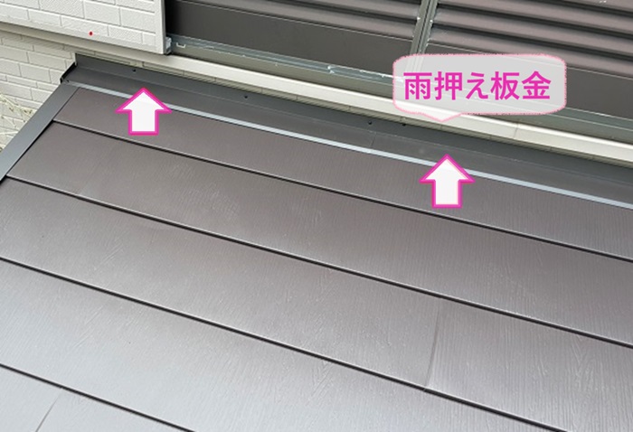下屋根のカバー工事で壁際に雨押さえ板金を取り付けている様子